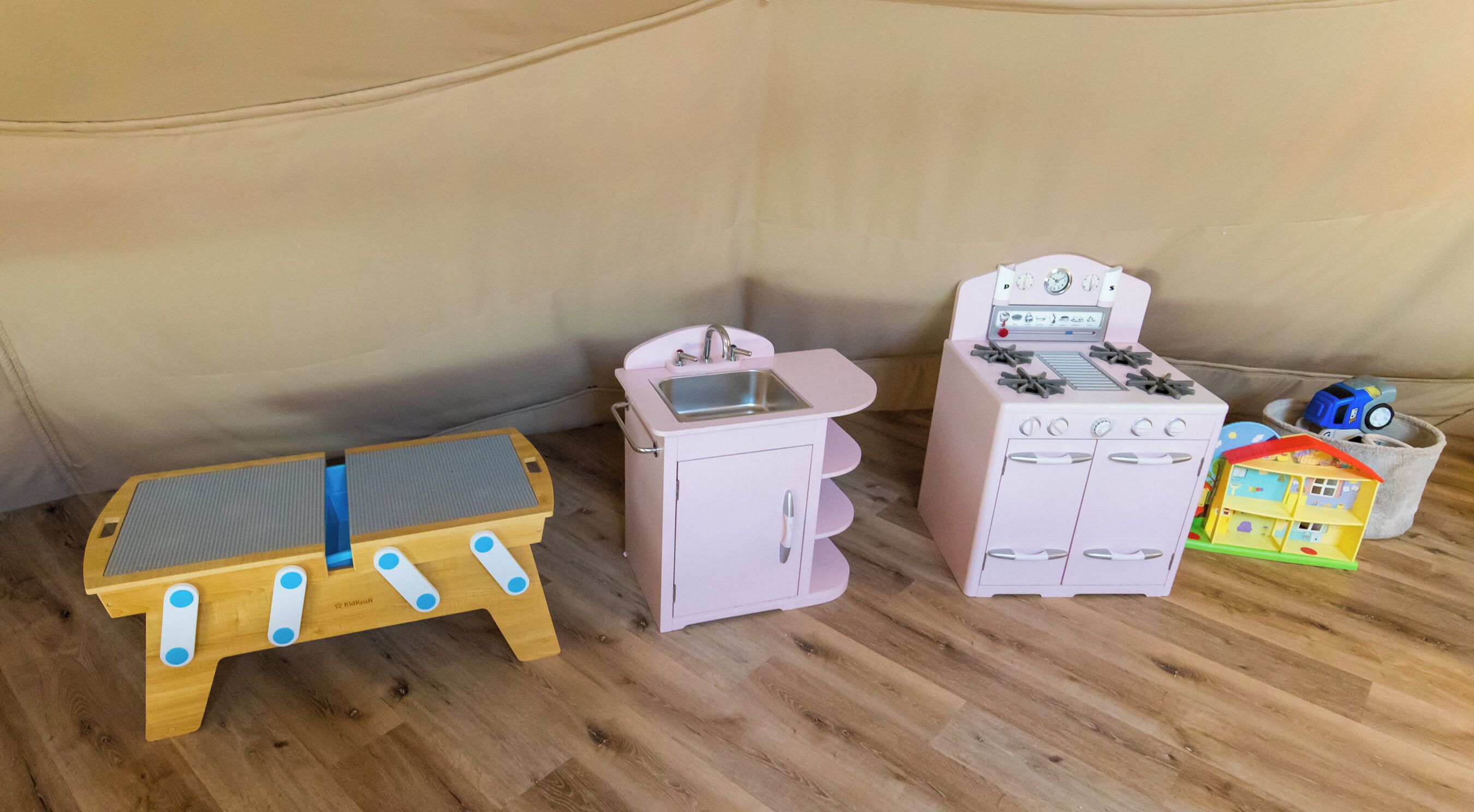 A play kitchen set with a sink, stove, and toy house.