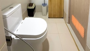 A compact bathroom with a toilet, a sink, and a mirror. - Room-style Studio Unit in Smdc (Iloilo)