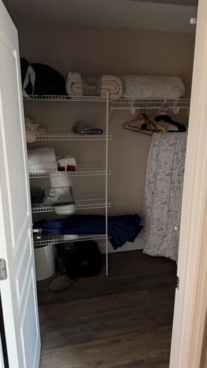 A walk-in closet with shelves, a hanging rack, and a bed. - 3-bedroom house in perfect Sarasota cool AC for relaxing stays with POOL hot tub (Sarasota)