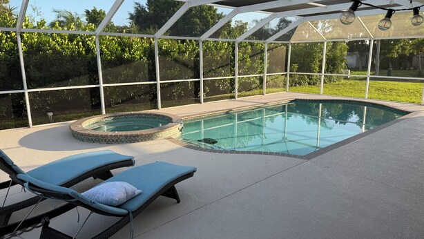 Una piscina con hidromasaje, rodeada por un porche techado con sillones de descanso.
