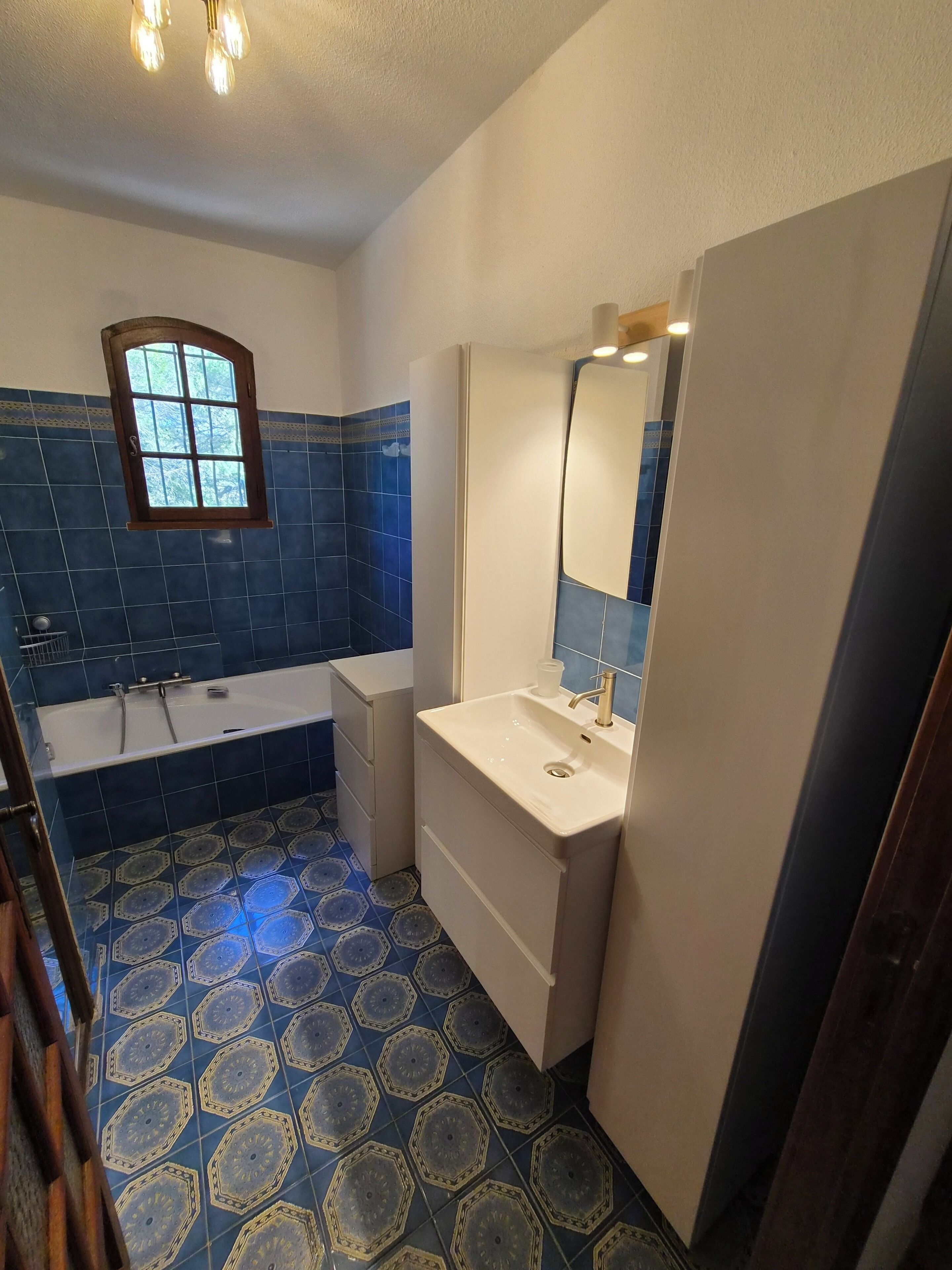Un baño con bañera, lavamanos y ventana.