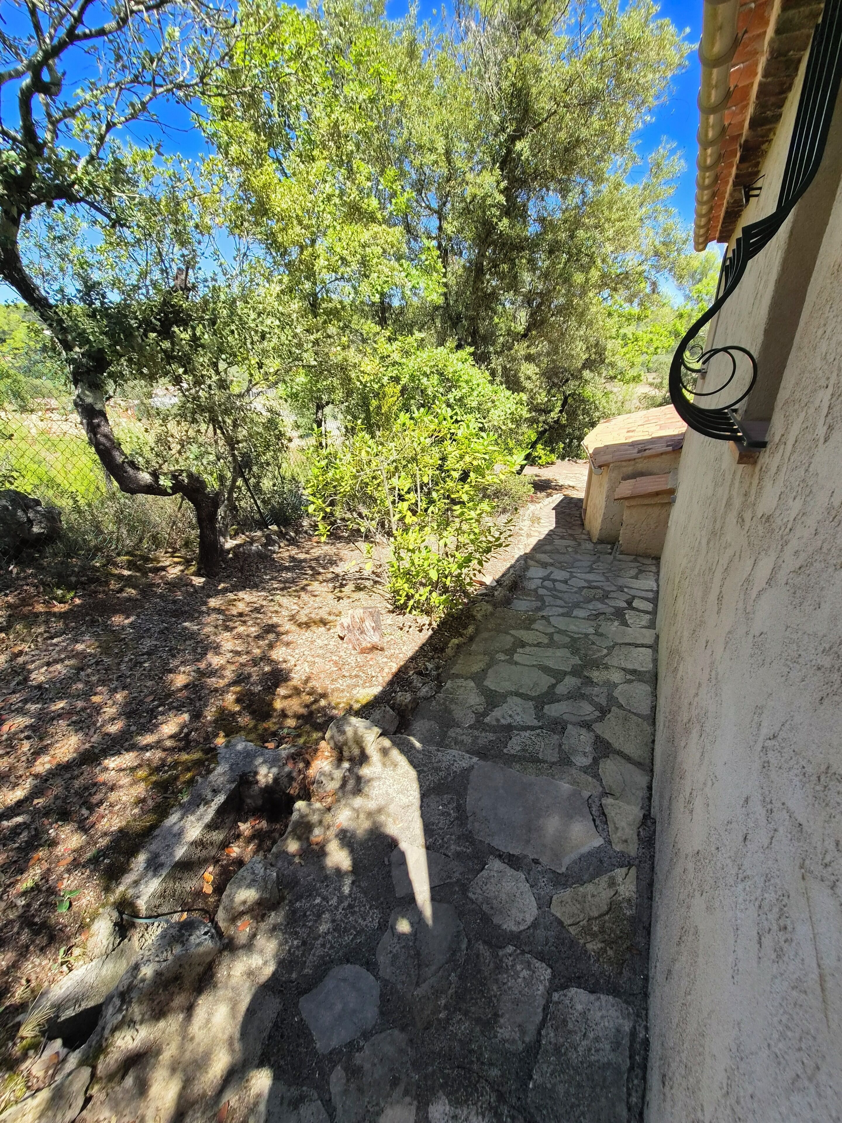 A stone pathway leading to a building with a metal railing.