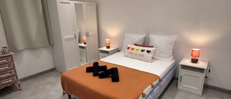 A bedroom with a bed, nightstands, a wardrobe, and a dresser.
