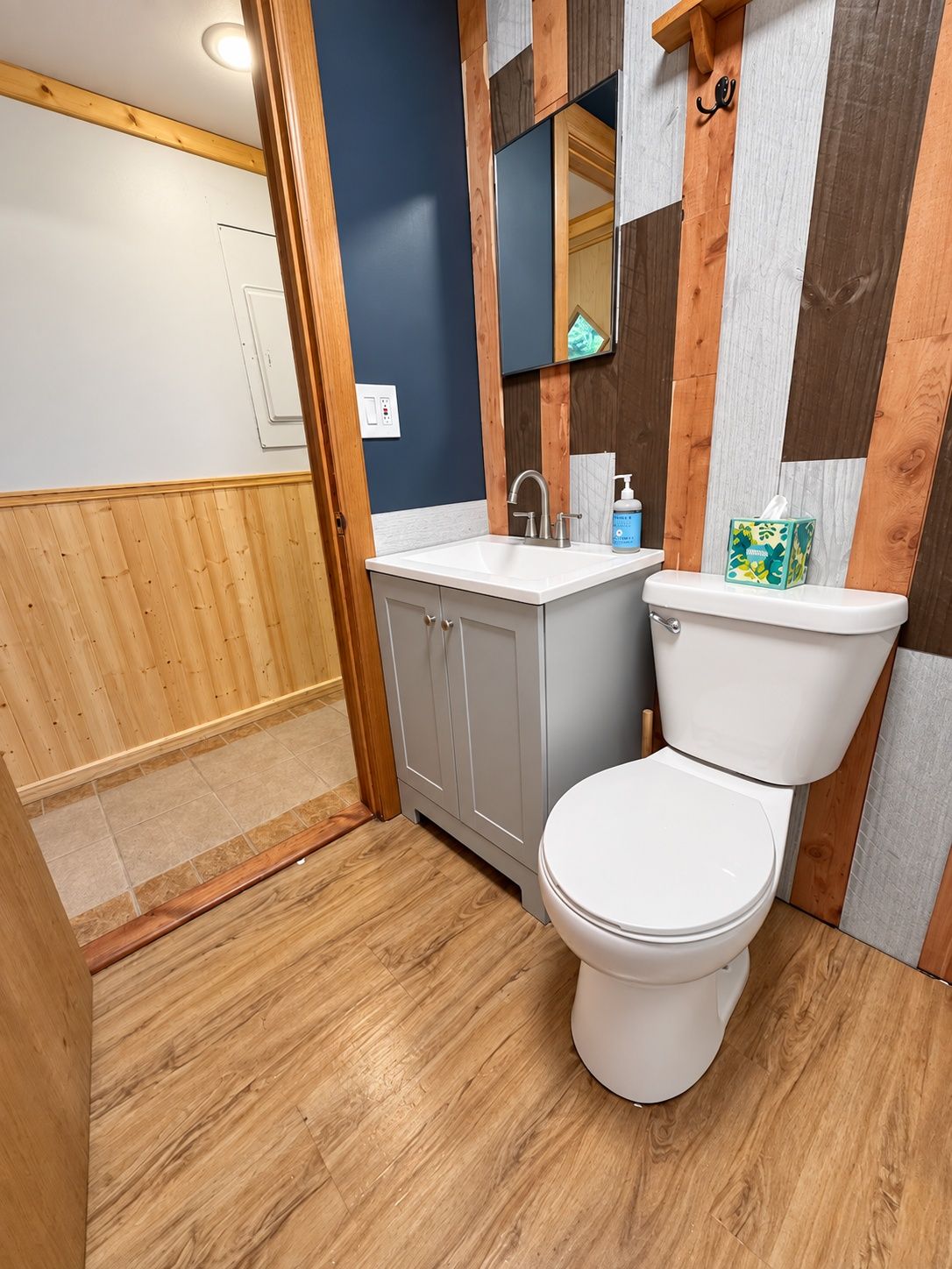 A bathroom with a toilet, sink, and mirror.