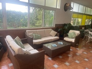 Um espaço amplo e interno com sofás, uma mesa de centro e uma mesa de jantar.