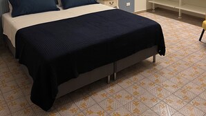 Un dormitori amb un llit, una làmpada de nit i un armari.