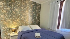 A bedroom with a bed, nightstand, lamp, and a ceiling fan. - Pousada Casa Hospedaria (Paraty)
