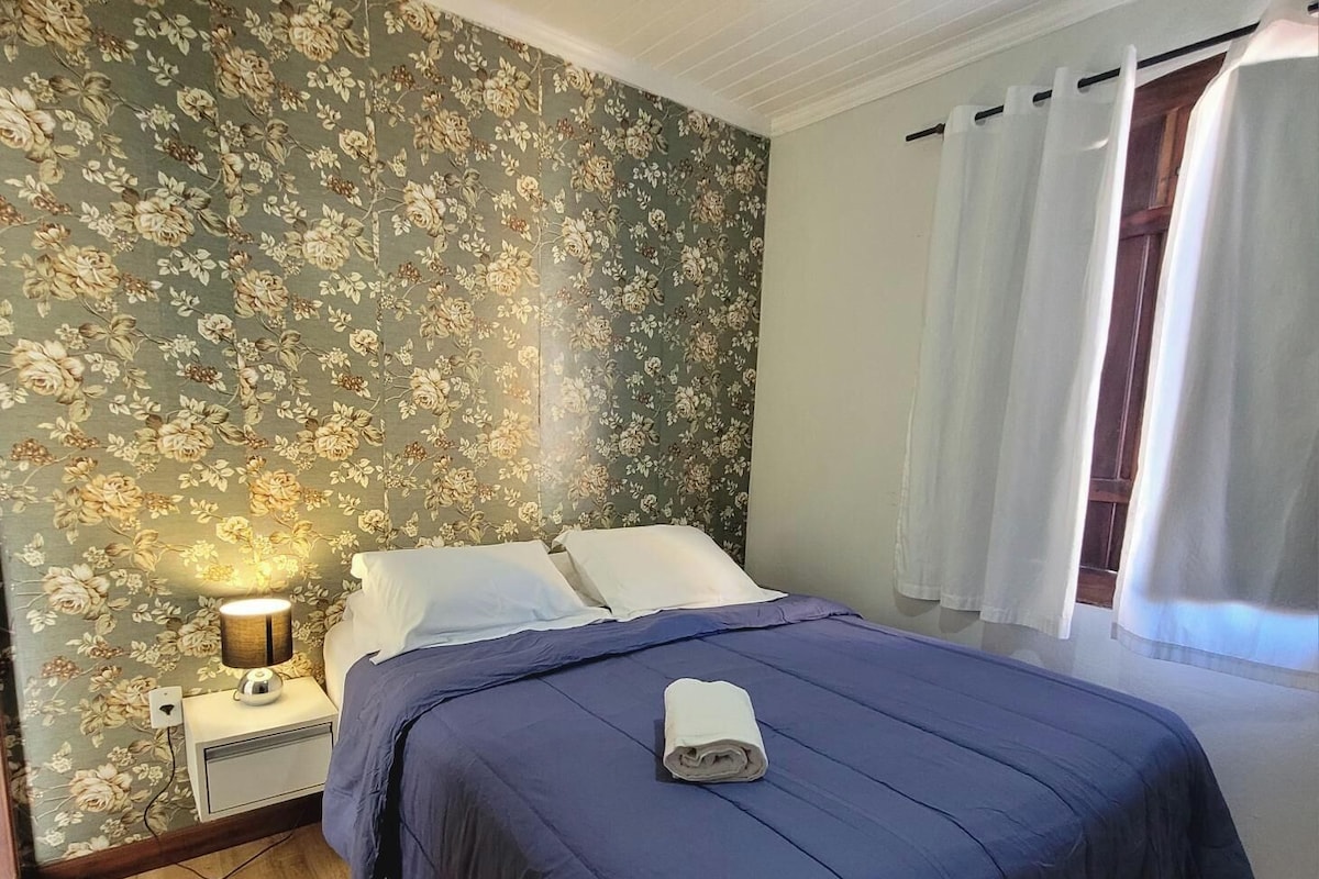 Ein Schlafzimmer mit Bett, Nachttisch, Lampe und Deckenventilator.