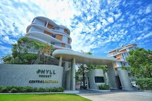 Ein modernes Gebäude mit einem geschwungenen Eingang, beschriftet mit 'PHYLL PHUKET CENTRAL PATTANA'.