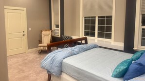A bedroom with a bed, a chair, and a window. - Cozy 1-bedroom private and secured with AC with an independent full bath (Surrey)