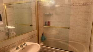 A bathroom with a sink, mirror, and a walk-in shower with a glass door. - Cozy 1-bedroom private and secured with AC with an independent full bath (Surrey)