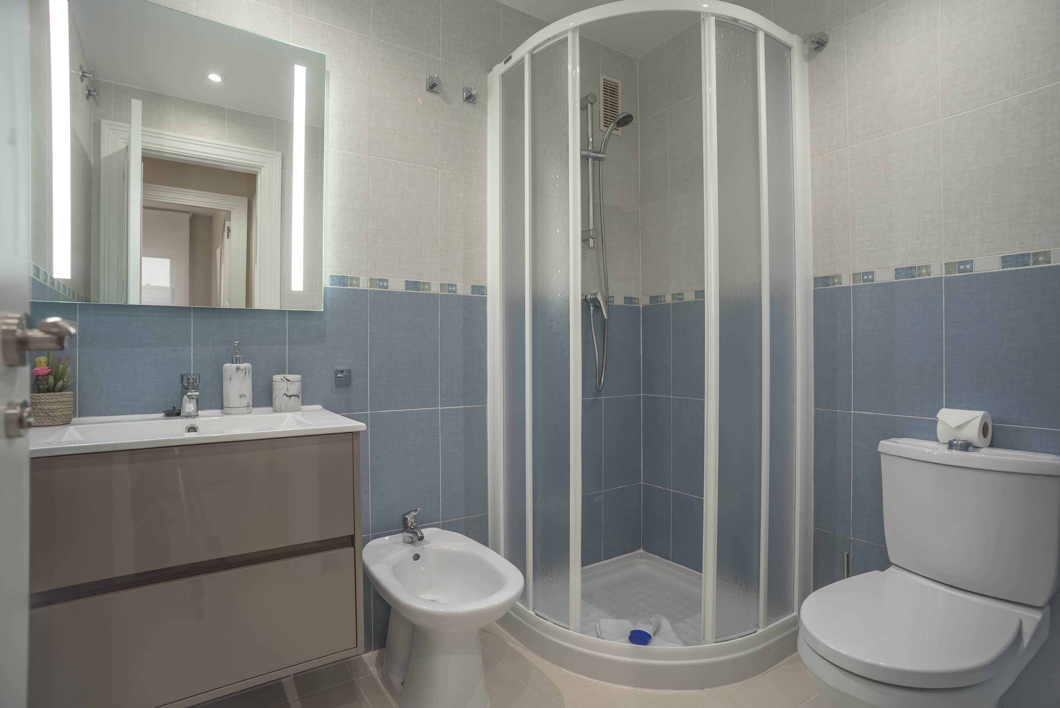 Ein modernes Badezimmer mit Duschkabine, Waschbecken, Bidet und Toilette.