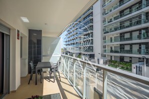 Eine moderne Wohnung mit Balkon, Essbereich und Blick auf umliegende Gebäude.
