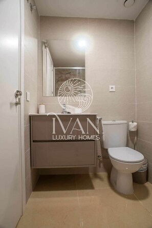 Ein Badezimmer mit Toilette, Waschbecken und Dusche.