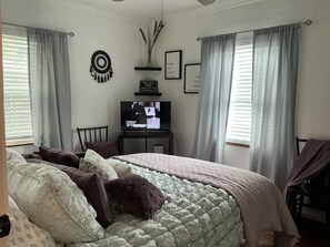 A bedroom with a bed, a television, and curtains. - Fabulous 2-bedroom house with AC in charming River Oaks (River Oaks)