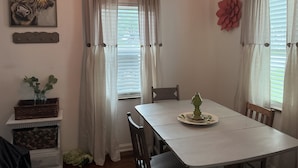 Un comedor con una mesa, sillas, un centro de mesa decorativo y un cuadro en la pared.