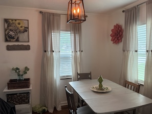 A dining area with a table, chairs, a decorative centerpiece, and a painting on the wall. - Fabulous 2-bedroom house with AC in charming River Oaks (River Oaks)