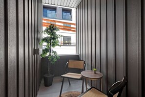 A small balcony with a potted plant, two wicker chairs, and a small table. - Family-Friendly 3BR/3.5BA in Fairmount near Center City Philadelphia (Philadelphia)