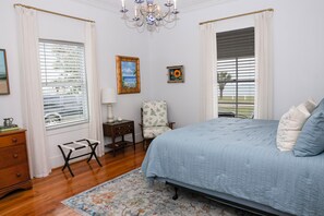 A bedroom with a bed, a chair, a nightstand, a lamp, and a painting. - Spacious 3 bed 2 1/2 bath home on Palacios waterfront. Great views and location. (Palacios)