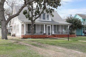 A two-story house with a covered porch and a brick foundation. - Spacious 3 bed 2 1/2 bath home on Palacios waterfront. Great views and location. (Palacios)