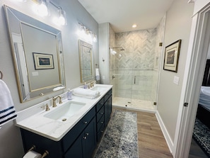 A bathroom with two sinks, a walk-in shower, and a large mirror. - Lake Travis Water Front - 180' Water Views  -3 beds and two baths (Jonestown)