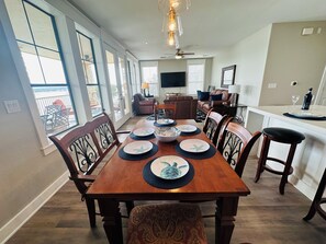 A dining area with a wooden table set for four, surrounded by chairs with intricate backs. - Lake Travis Water Front - 180' Water Views  -3 beds and two baths (Jonestown)