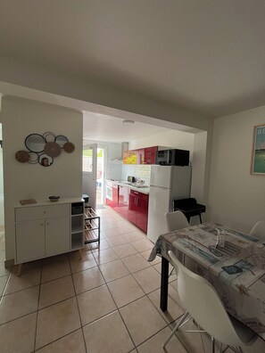 Un ambiente compatto con angolo cottura, zona pranzo e vista esterna.