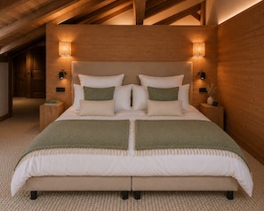 A bedroom with a large bed, wooden headboard, bedside lamps, and a carpeted floor. - SIGA Grand BO Chalet, Sleeps 14–16 — Newly Built and Fully Equipped (Le Grand-Bornand)