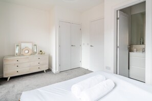 Une chambre à coucher avec un lit, une commode et deux portes.