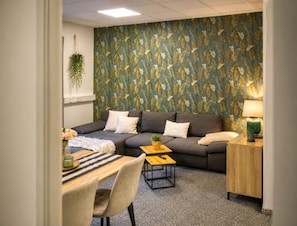 Ein Wohnzimmer mit einer Couch, einem Couchtisch und einer Lampe.