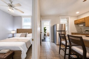 Ett hotellrum med en säng, ett sängbord, en lampa och en takfläkt.
