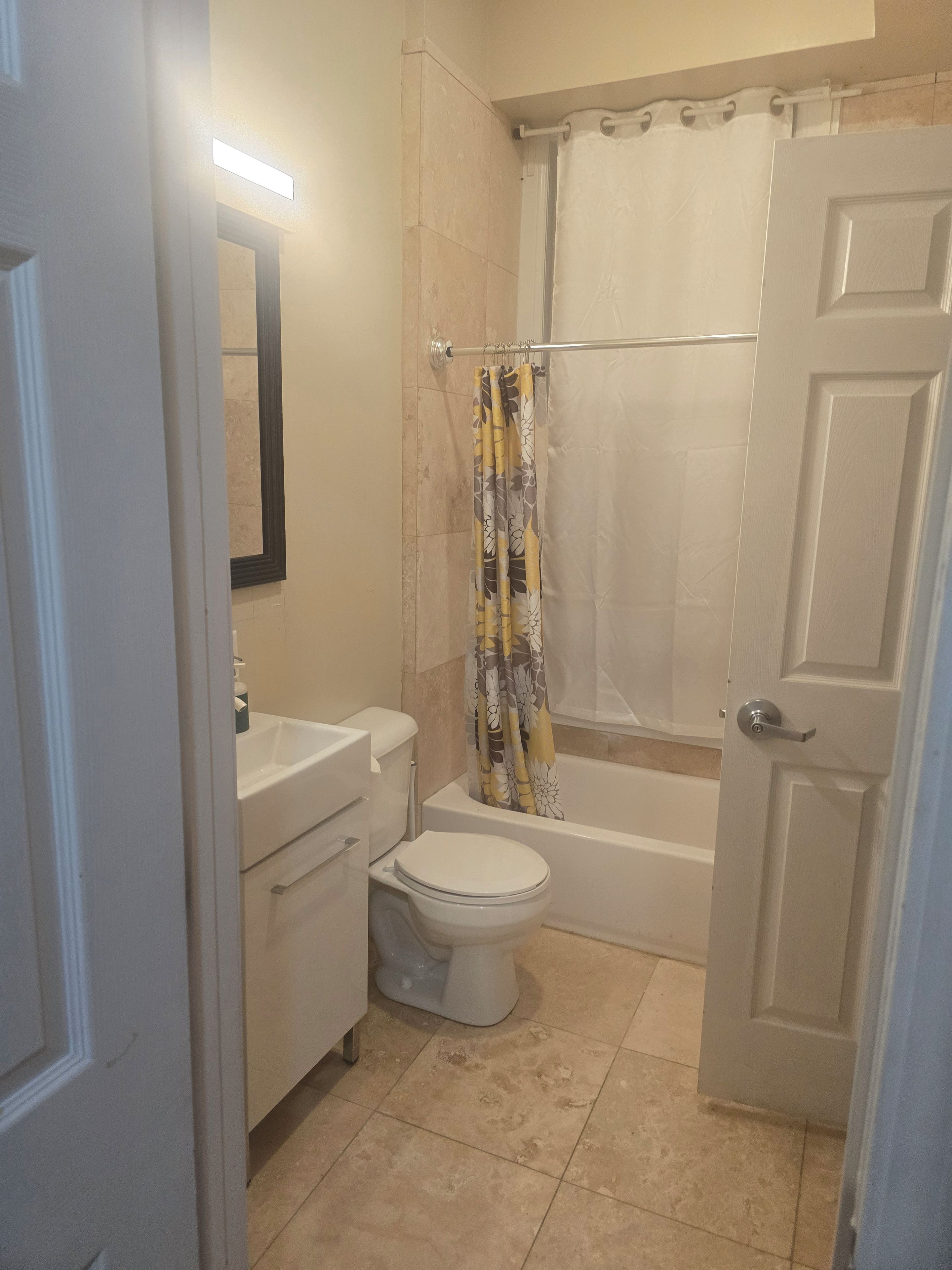 A bathroom with a toilet, sink, and bathtub.