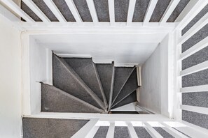 Eine Wendeltreppe mit weißen Geländern und grauen Stufen.