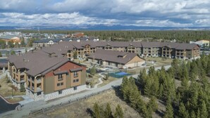 A residential complex with multiple two-story buildings, a central courtyard, and a swimming pool. - Cozy 1-bedroom condo in beautiful West Yellowstone with AC (West Yellowstone)
