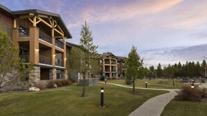 A multi-story hotel with a stone facade, balconies, and a landscaped lawn. - Cozy 1-bedroom condo with AC in pleasant West Yellowstone (West Yellowstone)