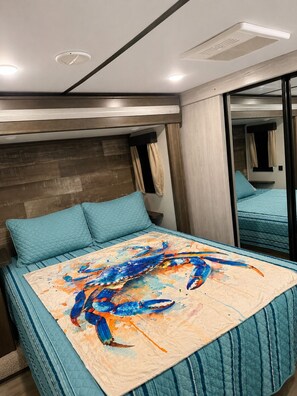 Ein Schlafzimmer mit einem großen Bett, einem Kopfteil, einem Fenster mit Vorhängen und einer Decke mit Einbauleuchten.