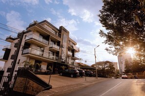 A multi-story building with balconies, a spa & nail bar, and a car parked in front. - Luxury 3-Bedroom Suite · Gishushu, Kigali (Kigali)