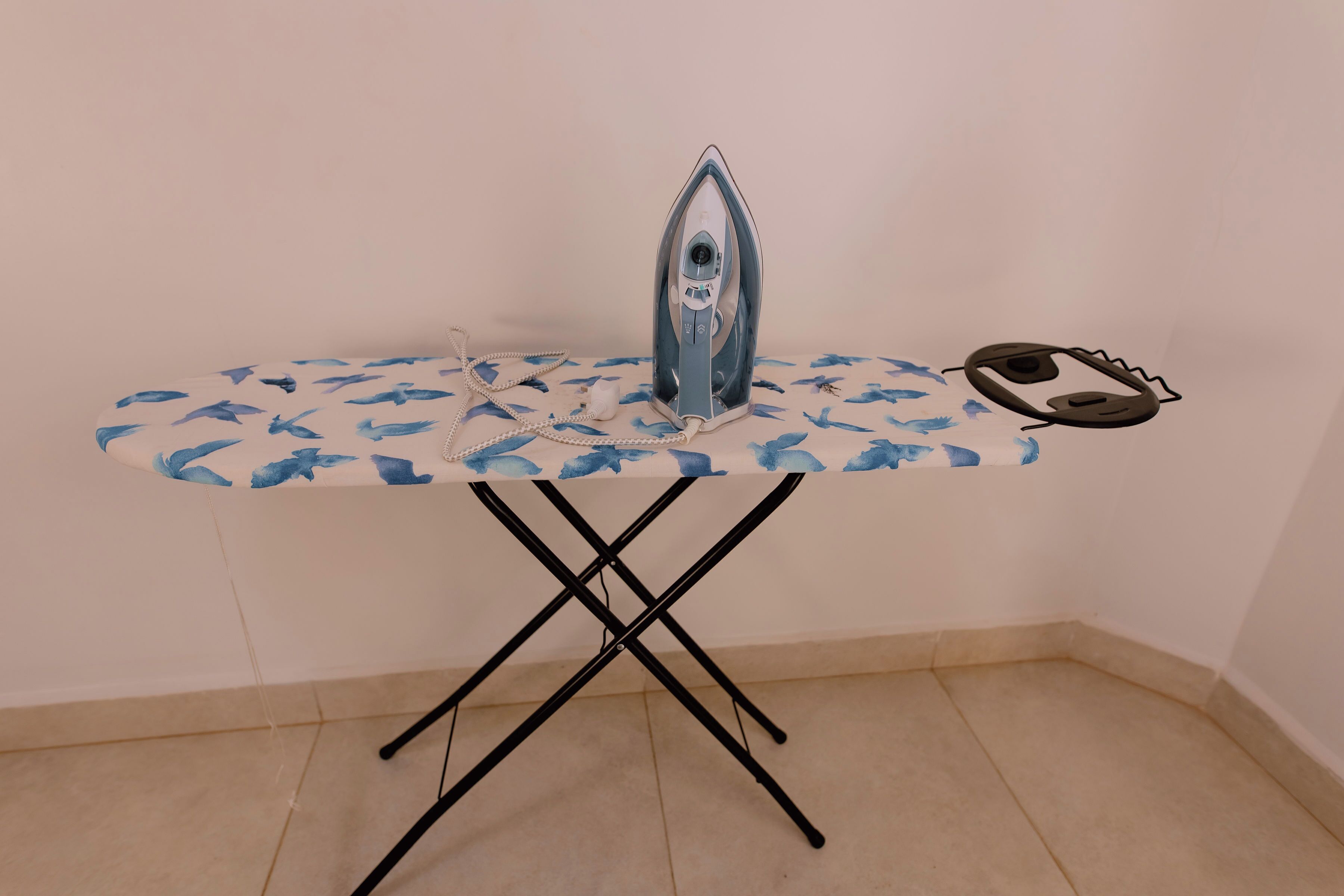 An ironing board with an iron and a pair of glasses on it.