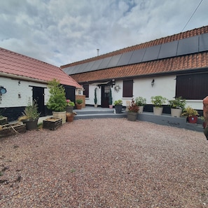 A courtyard with a gravel ground, potted plants, and buildings with red-tiled roofs. - Your own farmfouse (Béalencourt)