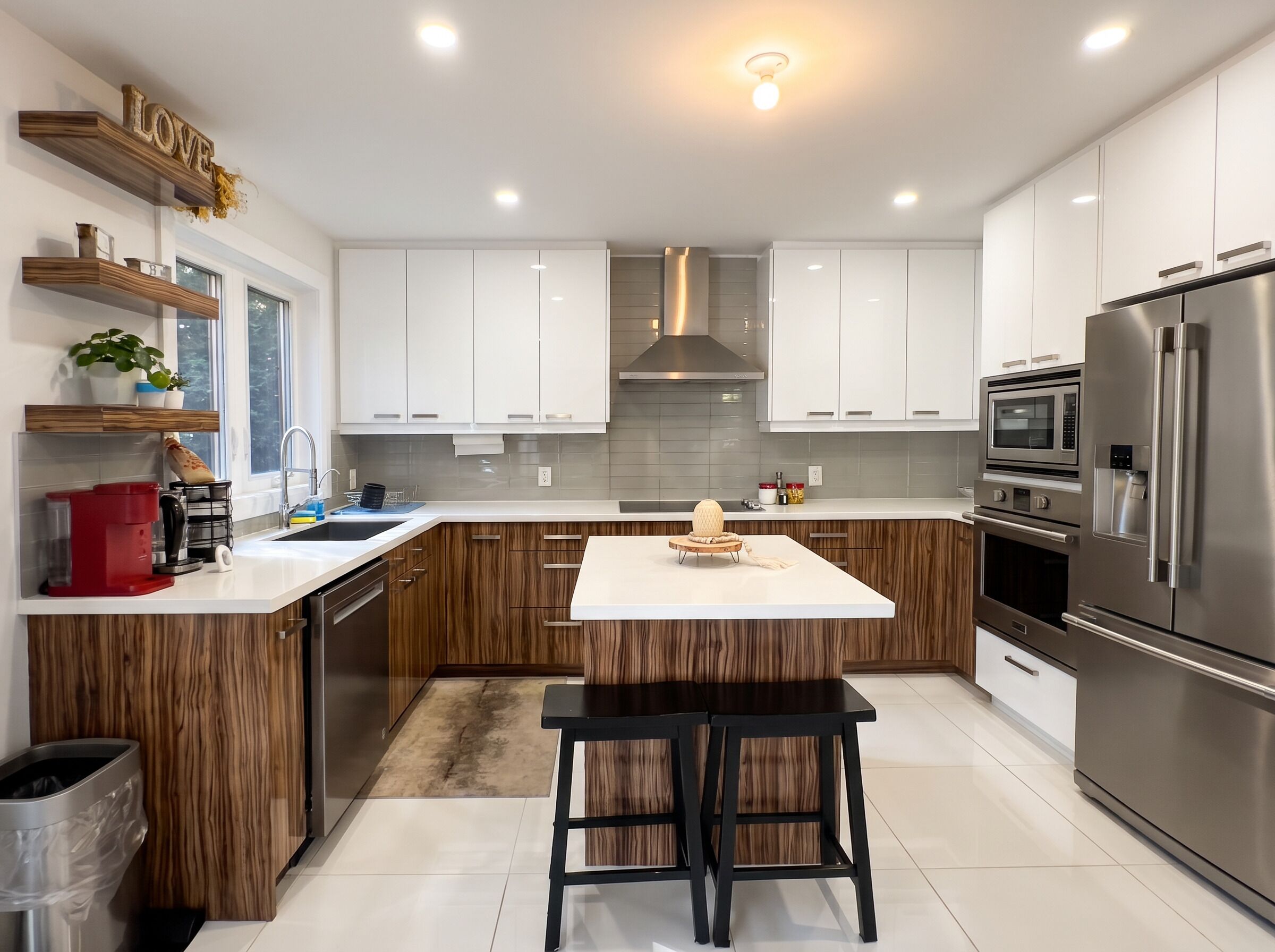 A modern kitchen with white cabinets, stainless steel appliances, and a central island.