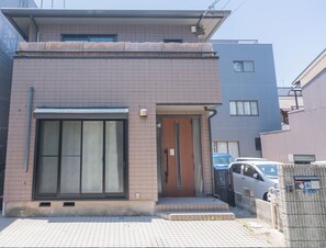 A modern two-story building with a large sliding glass door and a small entrance door. - CEREZO HOUSE
Family/Baby-Friendly 4 bedrooms,2 toilets, 2 bathrooms,Free parking (大阪市西成区天下茶屋3-16-6)
