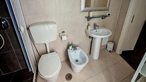 Un baño con inodoro, bidé y lavamanos.