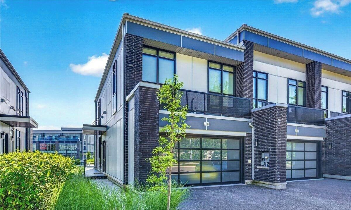 Een modern gebouw met twee verdiepingen, een plat dak, grote ramen en een gevel van baksteen.
