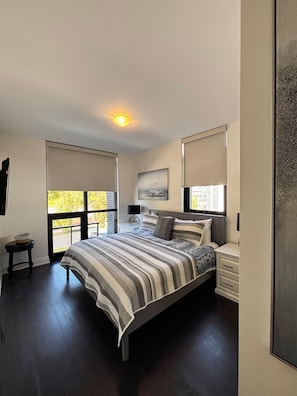 A bedroom with a large bed, a nightstand, a lamp, and a painting on the wall. - Your Friday Harbour Escape Awaits! (Innisfil)