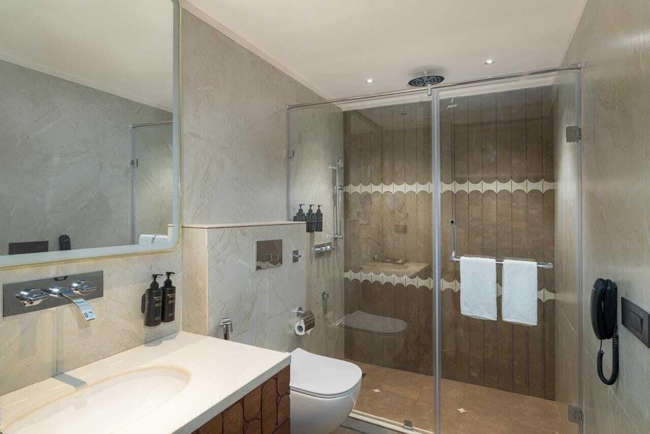 Une salle de bain moderne avec une douche à parois de verre, un lavabo blanc et des toilettes.