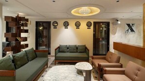 Una sala de estar moderna con un sofá, sillones, una mesa de centro y una estantería.