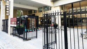 A courtyard with a black wrought iron fence, outdoor seating, and a storefront with a sign. - Vrbo Property (Buenos Aires)