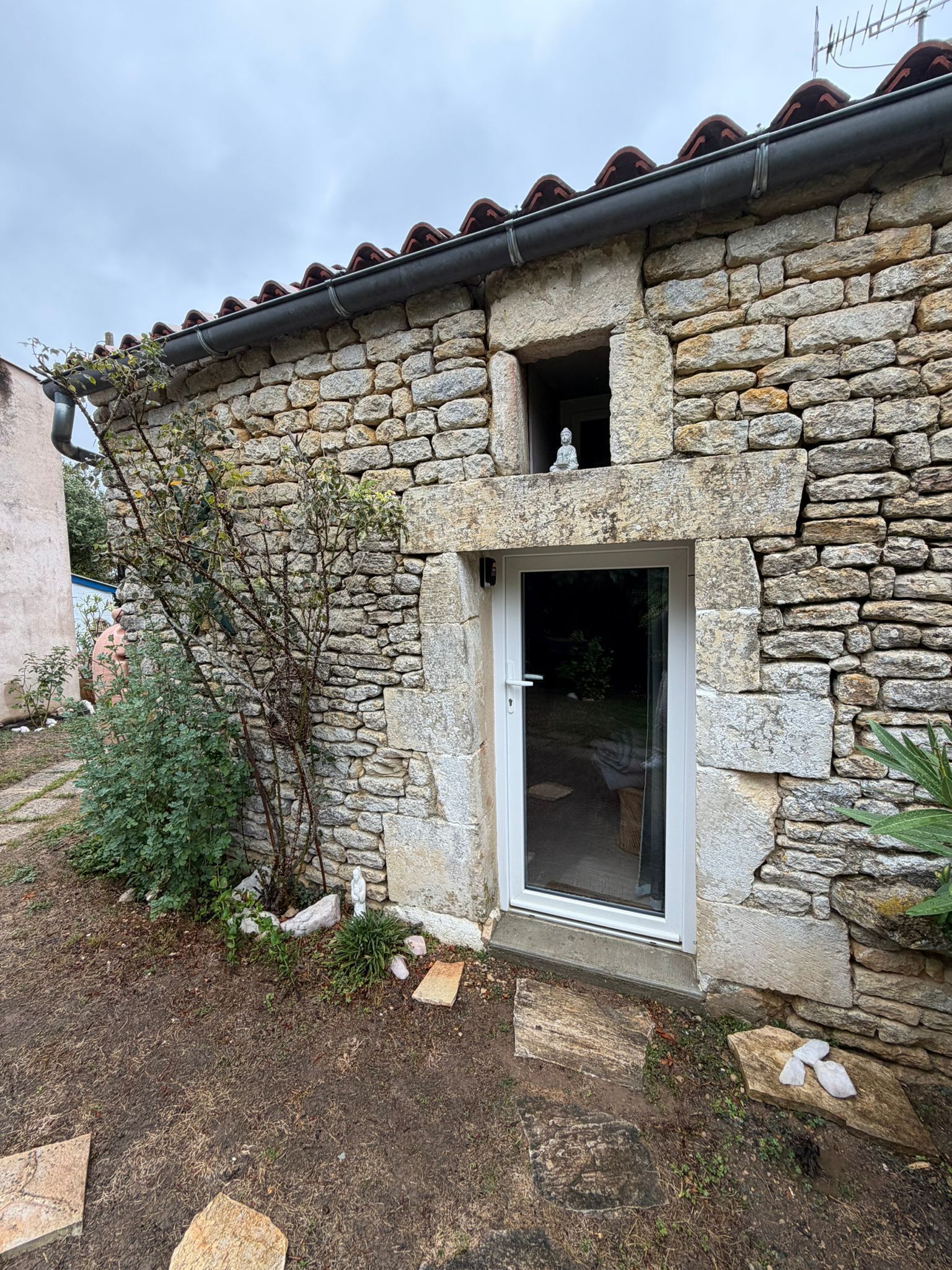 A stone building with a small doorway and a window.