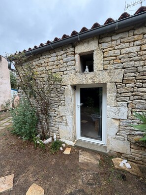 Ein Steinhaus mit einer kleinen Tür und einem Fenster.