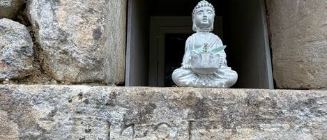 A stone Buddha statue in a niche with inscriptions.